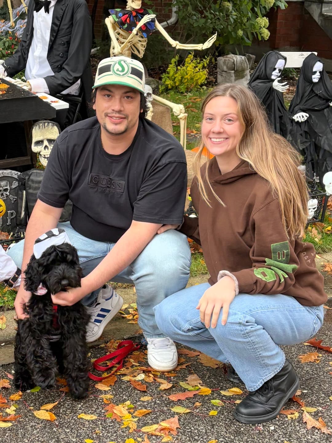 Chelsea, Garnet and Bambino crouched among fallen leaves on a street decorated for Halloween